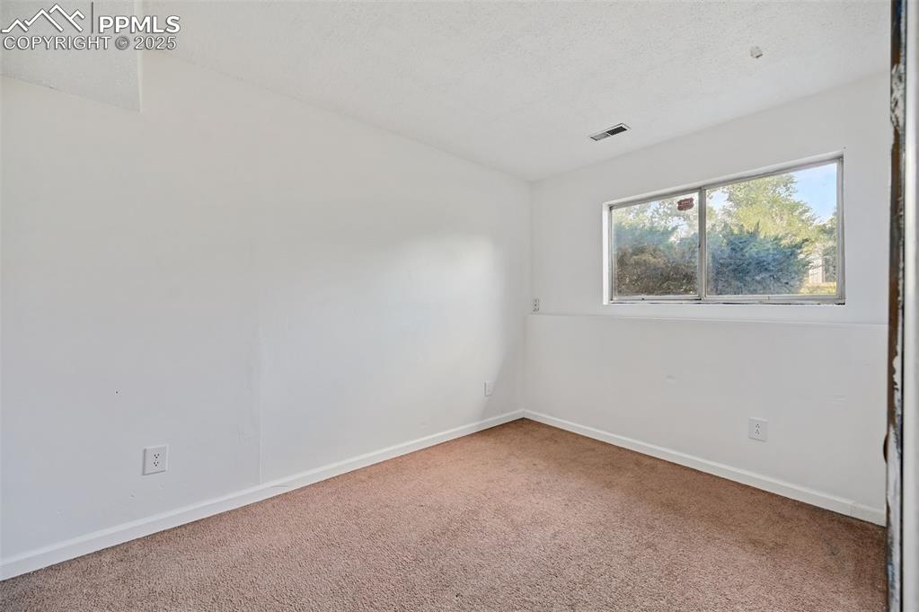 Image 11 of 19: Spare room with carpet and a textured ceiling