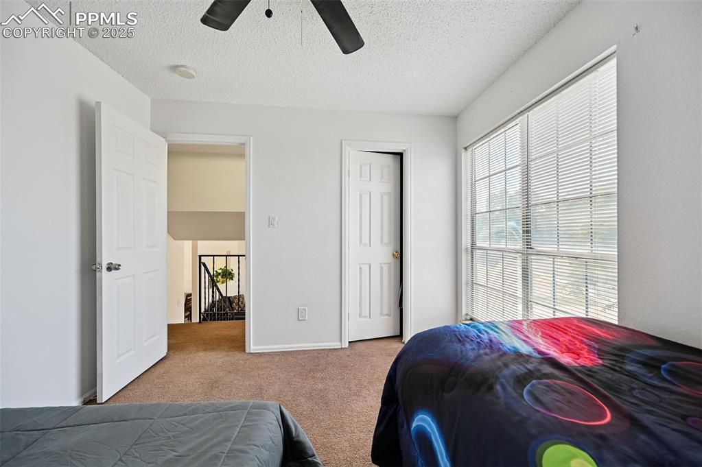 Image 15 of 19: Carpeted bedroom featuring a textured ceiling, a ceiling fan, and a closet