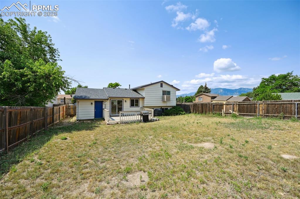 Image 19 of 19: Rear view of property with a fenced backyard and a deck