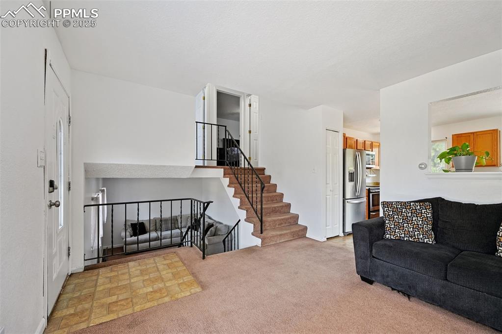 Image 2 of 19: Living room with stairway and light colored carpet