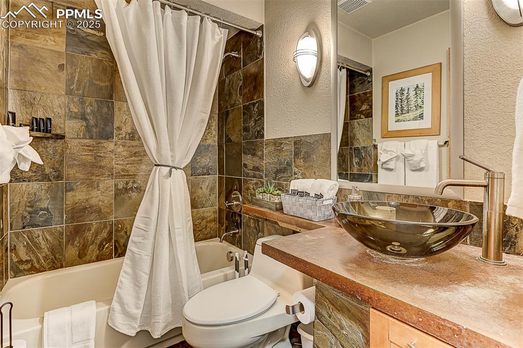 Image 23 of 42: Bathroom 2 featuring shower / bath combination with curtain, vanity, and a