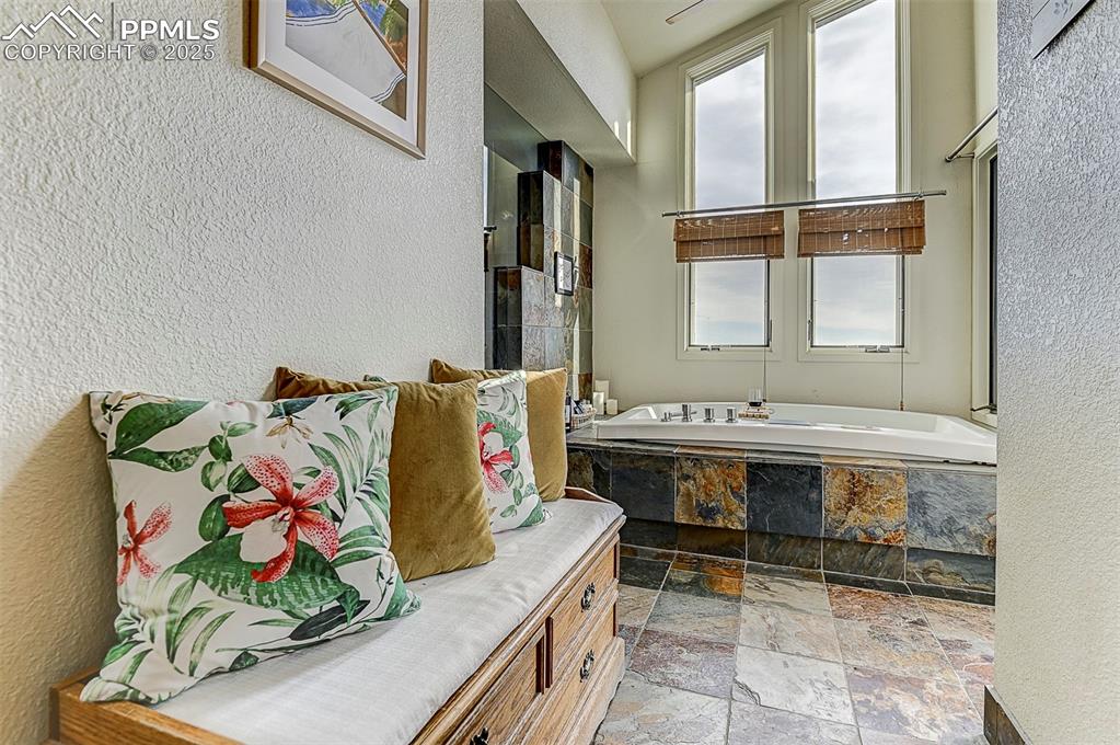 Image 33 of 42: Bathroom suite featuring a sitting area, a garden tub, plenty of natural li