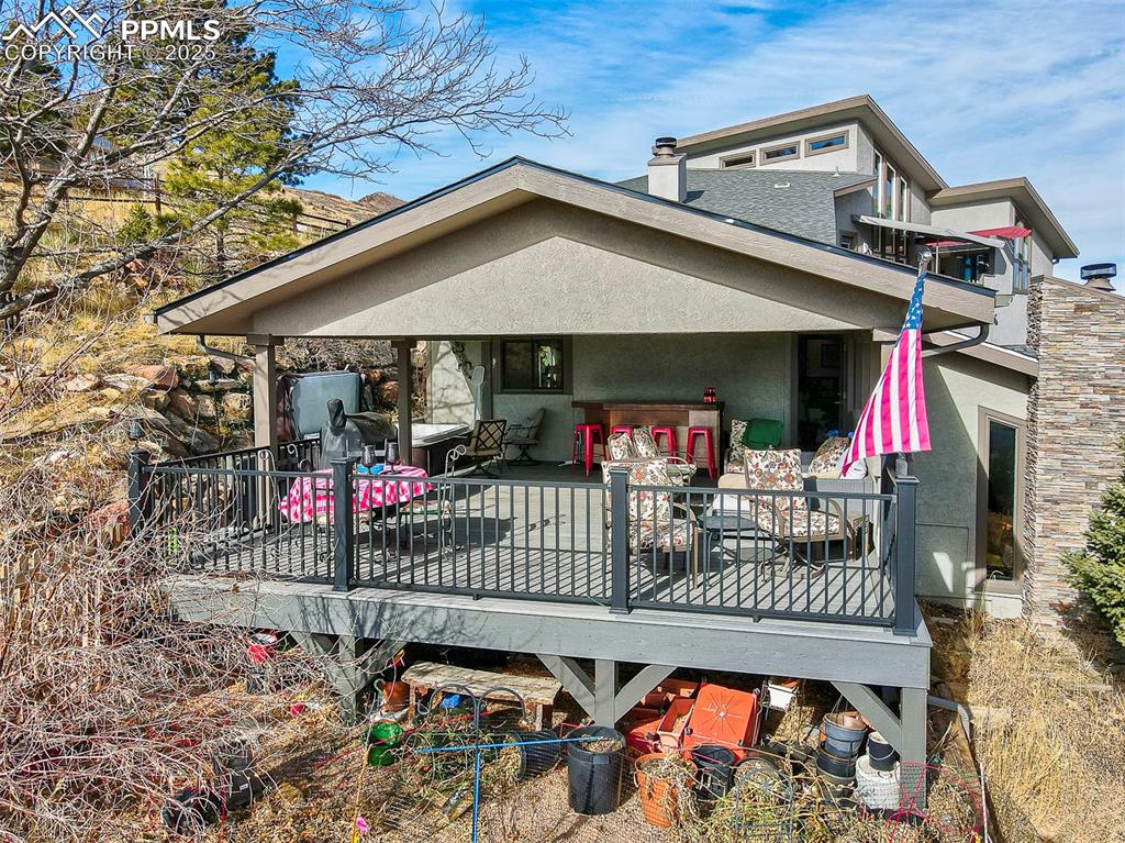 Image 39 of 42: South side of house with stucco siding, a new tree deck, a chimney, and ou