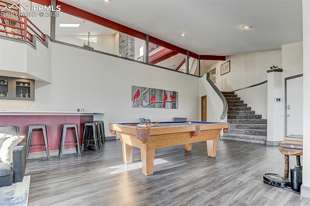 Image 5 of 42: Game room featuring high vaulted ceiling, billiards table, light wood-type