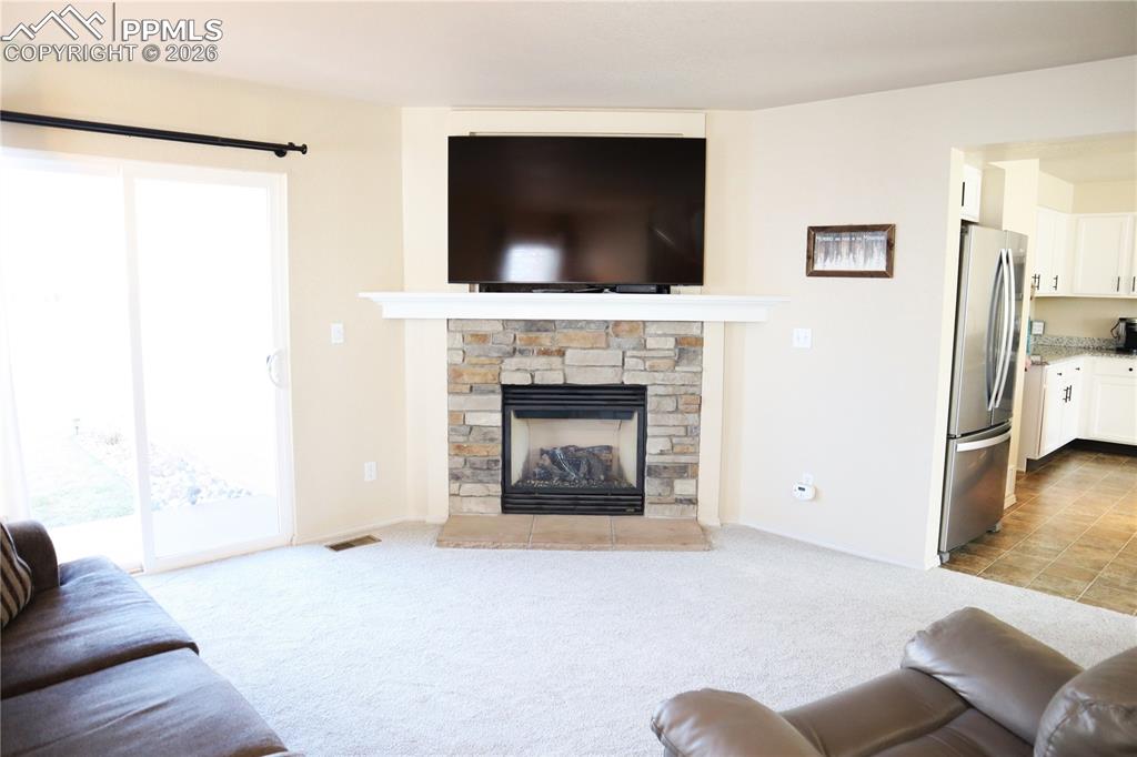Image 4 of 34: Living Room looking to the Fireplace and Sliding Doors.