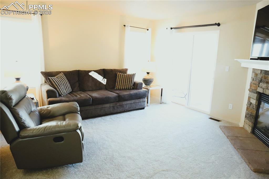 Image 5 of 34: Living Room looking to the Fireplace and Sliding Doors to the Backyard.