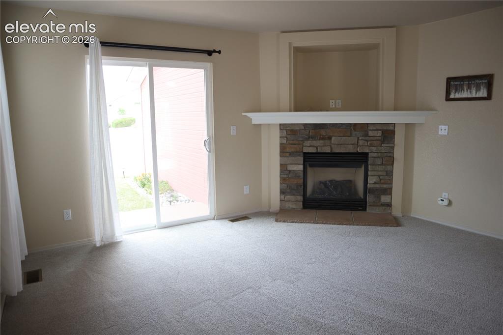 Image 5 of 34: Living Room looking to the Fireplace and Sliding Doors to the Backyard.
