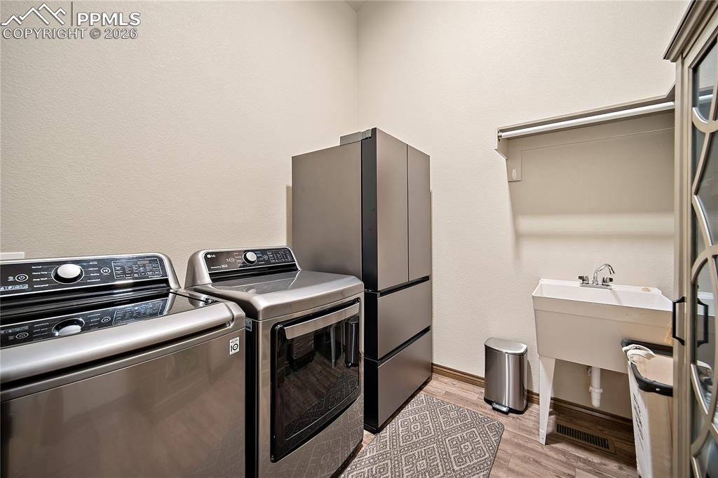 Image 20 of 49: Main level laundry with sink and shelving.