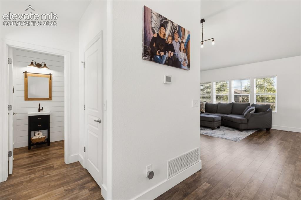 Image 6 of 41: Left of entry is a large and nicely remodeled half bath