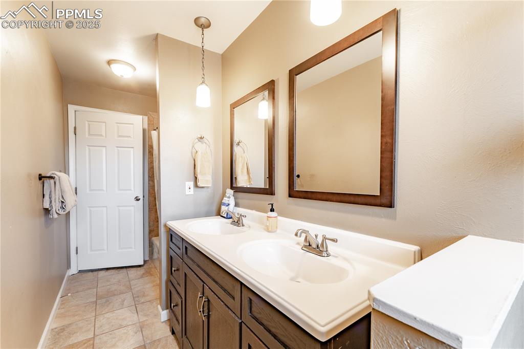Image 18 of 39: Full bath with double vanity and light tile patterned flooring