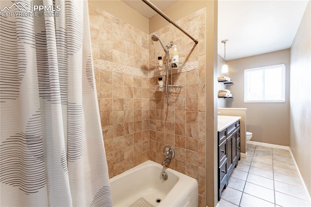 Image 19 of 39: Bathroom featuring vanity, shower / bath combo, and light tile patterned fl