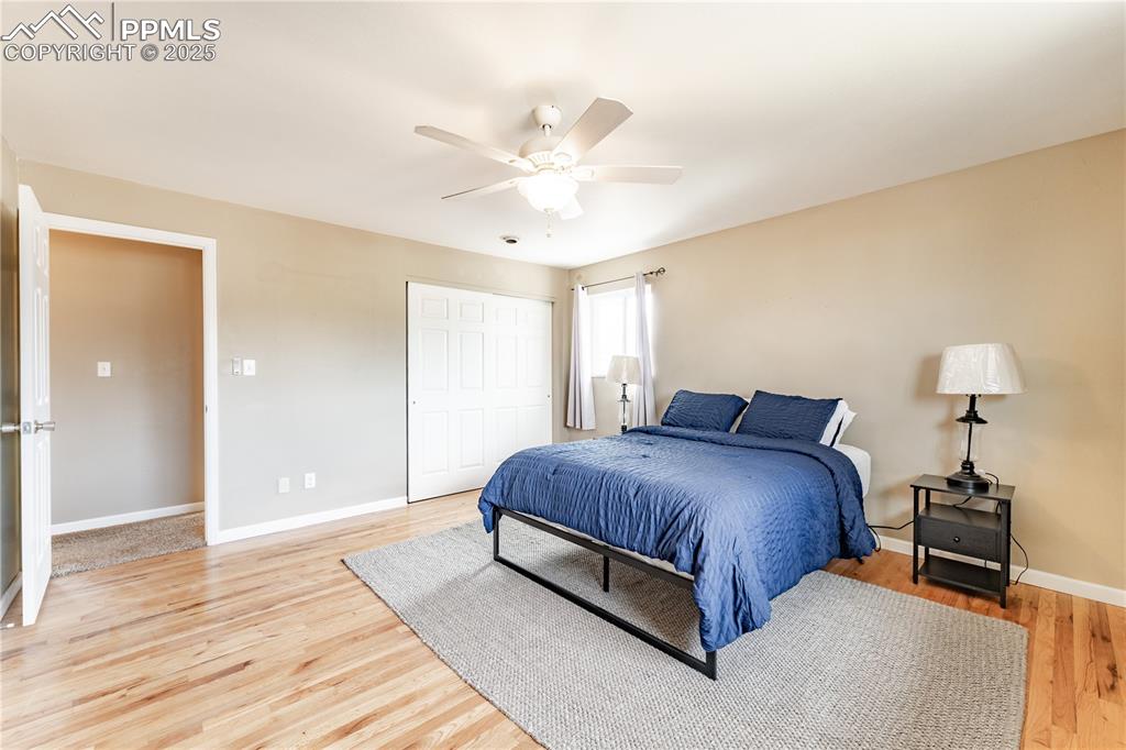 Image 21 of 39: Bedroom featuring a closet, ceiling fan, and light wood-type flooring