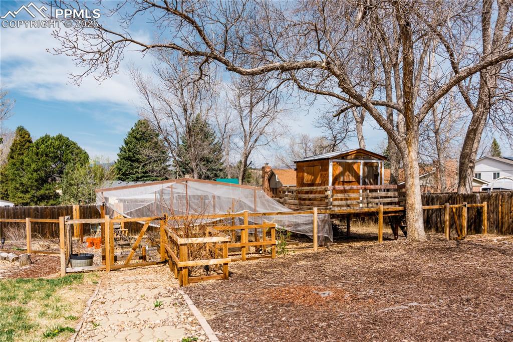 Image 9 of 39: View of yard featuring an outbuilding, exterior structure, and a garden
