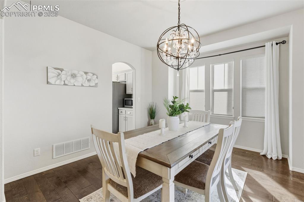 Image 11 of 41: Dining room featuring hardwood / wood-style floors, arched walkways, and a 