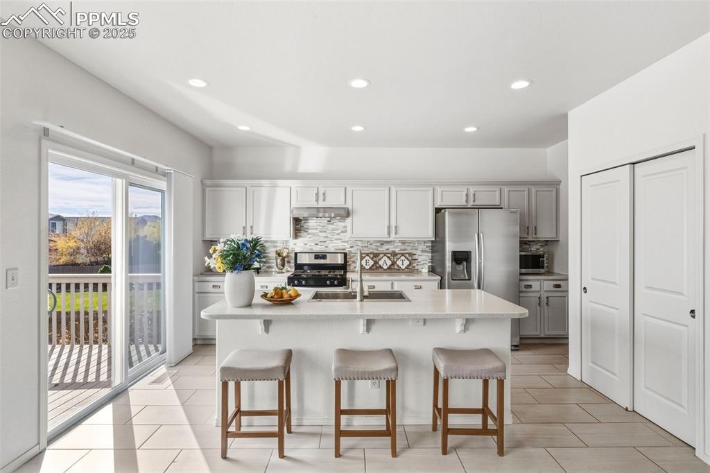 Image 12 of 41: Kitchen with a breakfast bar, tasteful backsplash, stainless steel applianc