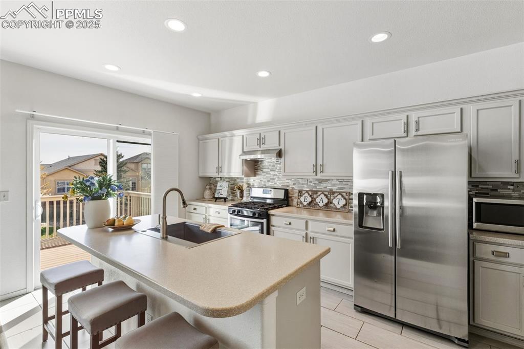 Image 14 of 41: Kitchen featuring appliances with stainless steel finishes, an island with 