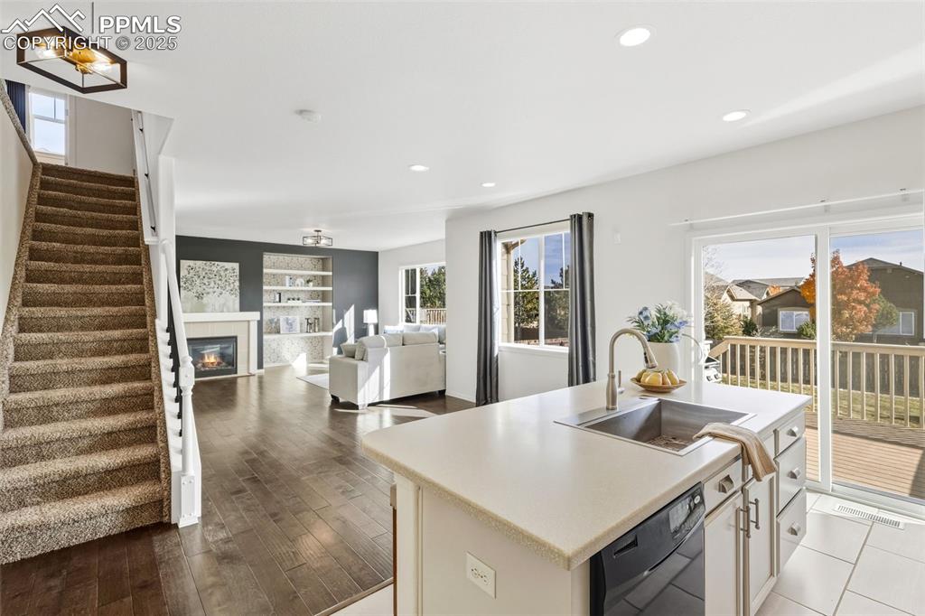 Image 16 of 41: Kitchen featuring light countertops, a kitchen island with sink, black dish