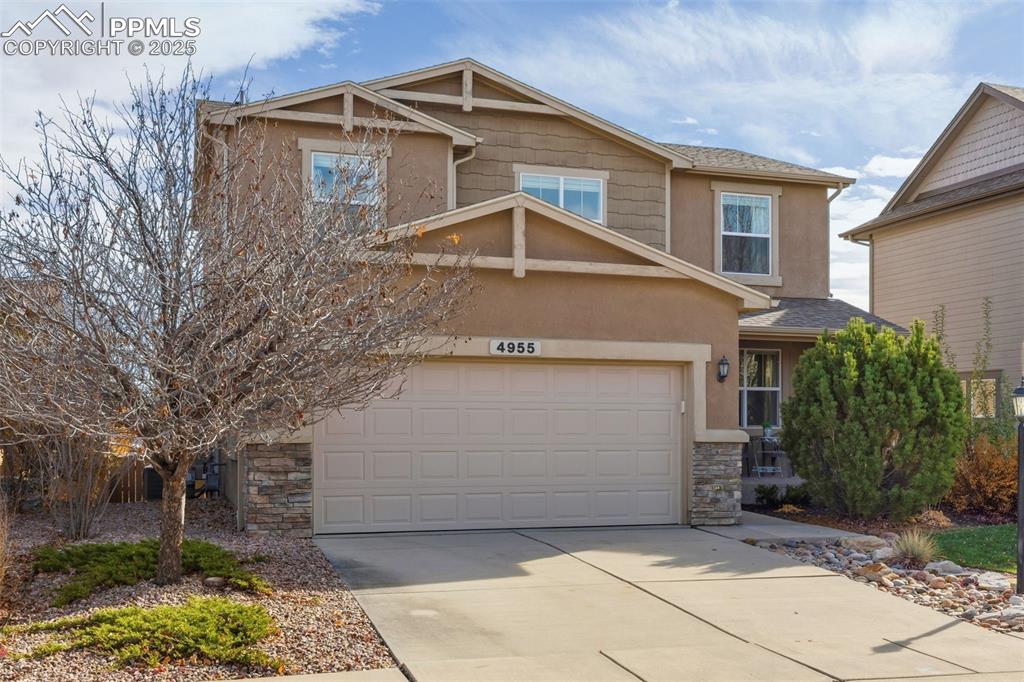 Image 2 of 41: Craftsman house featuring stone siding, driveway, a garage, and stucco sidi