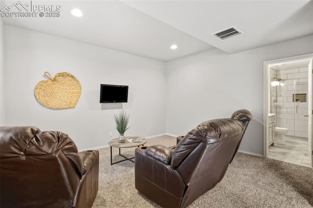 Image 31 of 41: Living area with light carpet and recessed lighting