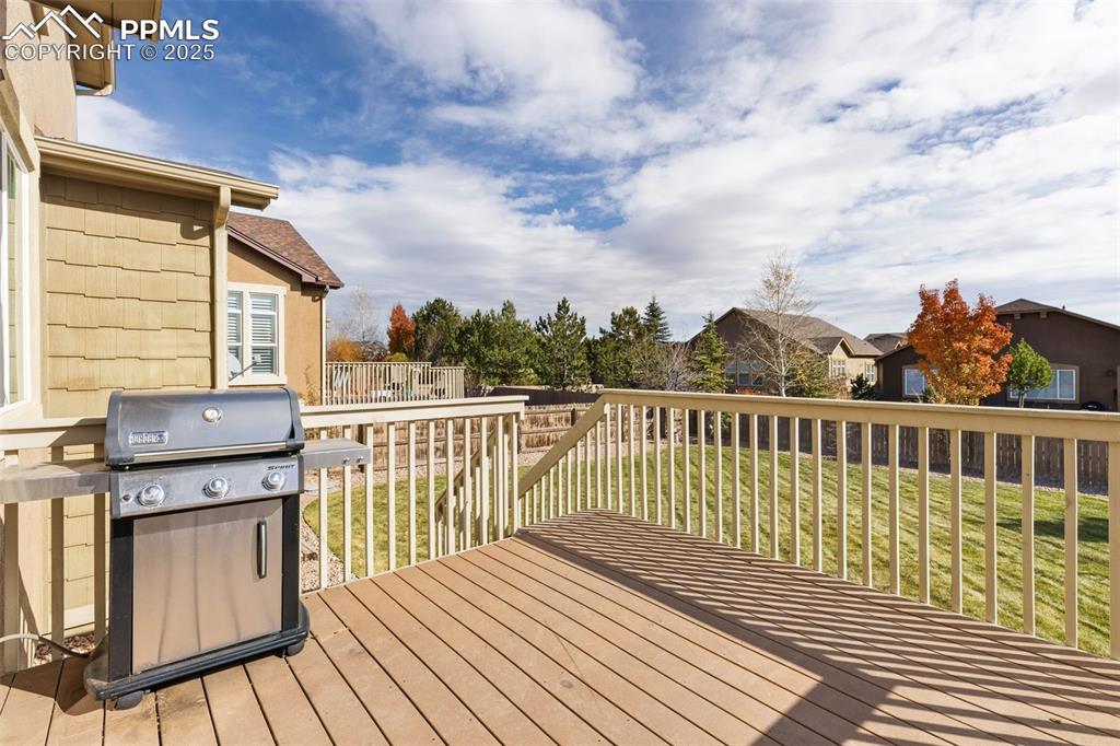 Image 34 of 41: Wooden deck with area for grilling, a yard, and a residential view