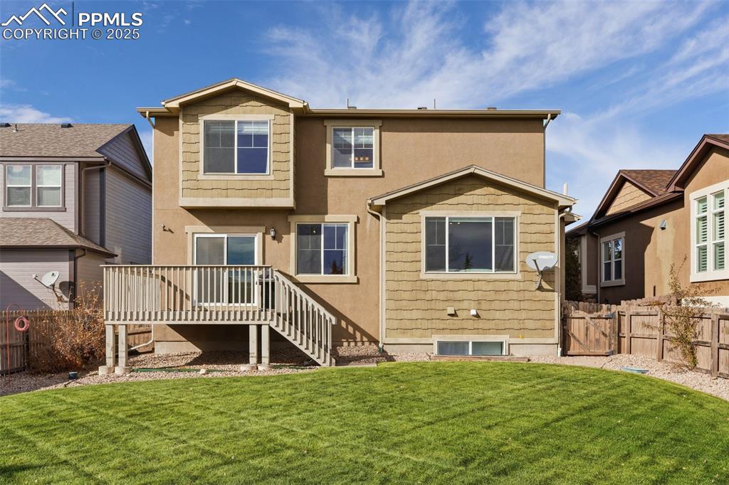 Image 36 of 41: Rear view of property with stairs, a wooden deck, and stucco siding