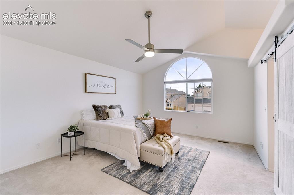 Image 16 of 47: Vaulted ceiling, arched window, ceiling fan with integrated lighting, and a