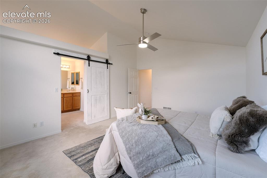Image 18 of 47: Vaulted ceiling, ceiling fan with light fixture, light-toned carpeting, whi