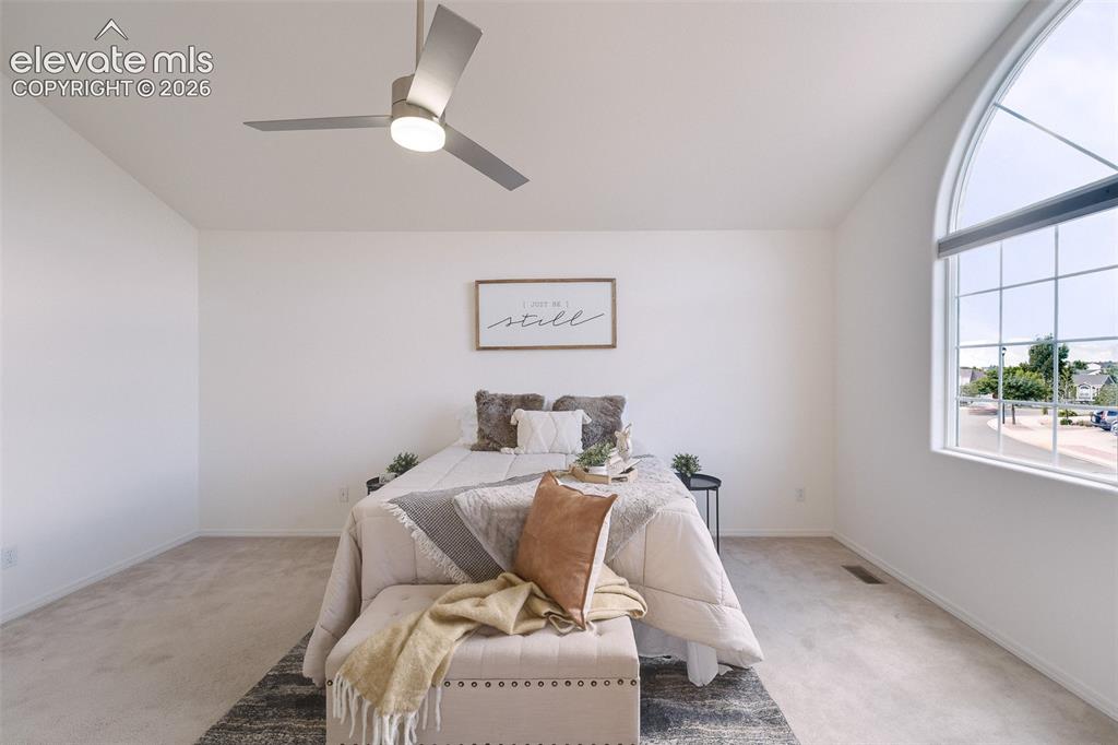 Image 20 of 47: Vaulted ceiling with a contemporary ceiling fan, large arched window, light