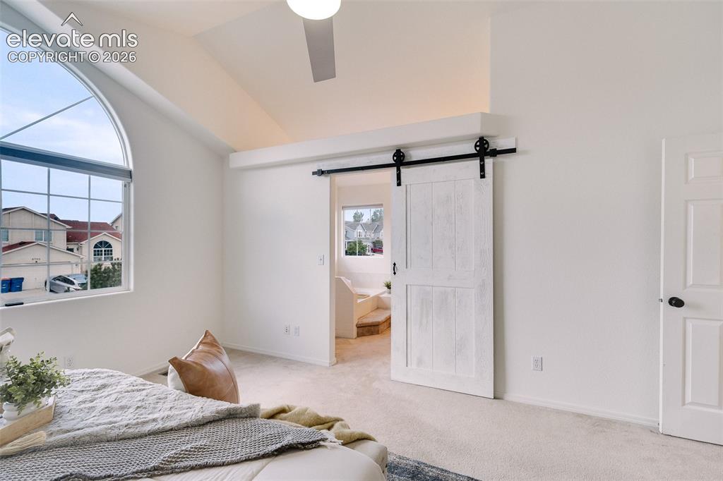Image 21 of 47: Arched window with gridded panes, vaulted ceiling, ceiling fan, white barn 