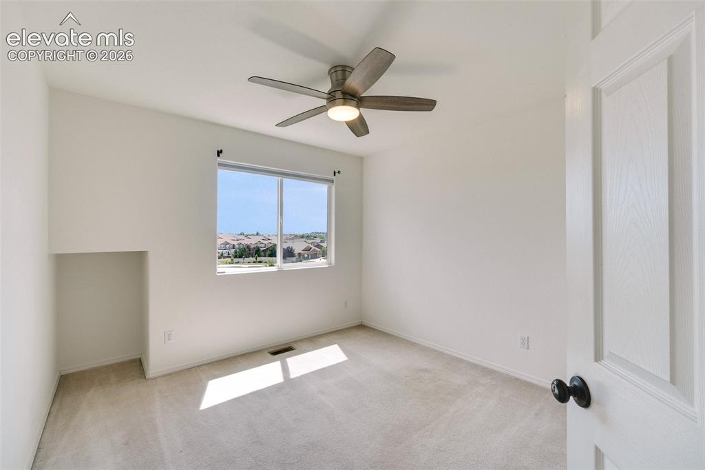 Image 30 of 47: Bright interior with neutral carpet flooring, a ceiling fan, and a window o