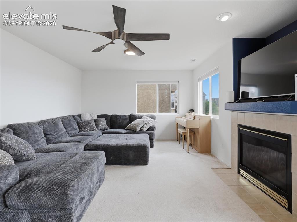 Image 36 of 47: Living space featuring a tiled fireplace with a black insert, an integrated