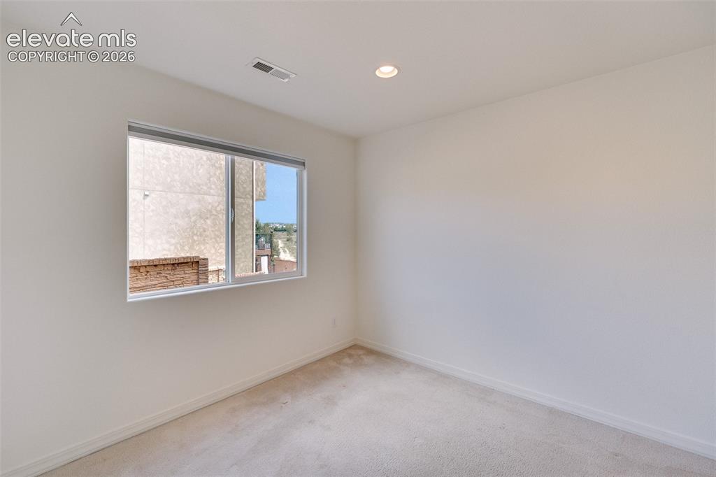 Image 39 of 47: Recessed ceiling lighting, white walls, and light-toned carpeting