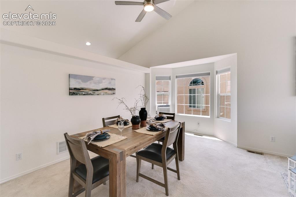 Image 8 of 47: Vaulted ceiling with a ceiling fan, recessed lighting, and a bay window