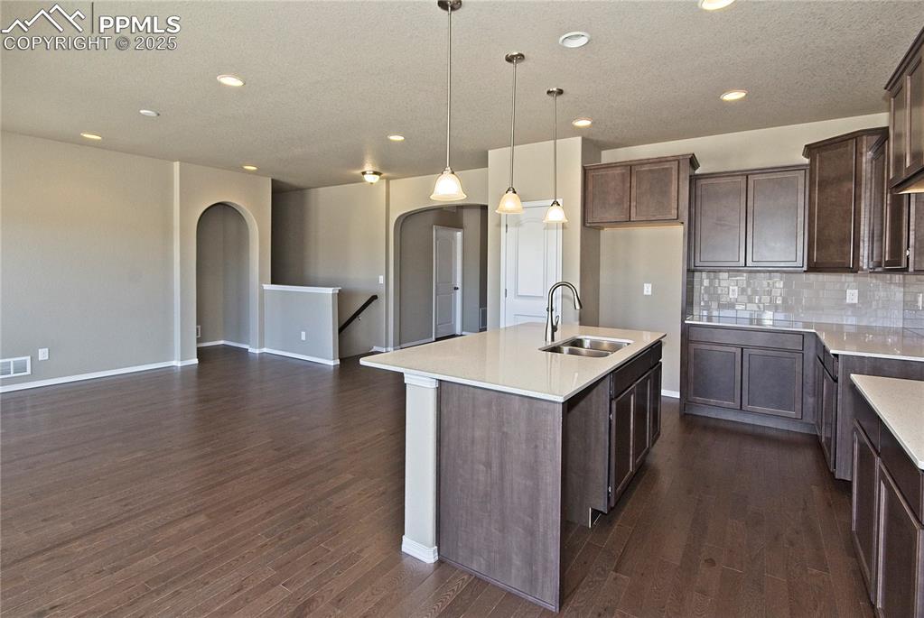 Image 10 of 25: Kitchen featuring decorative backsplash, recessed lighting, dark wood-style