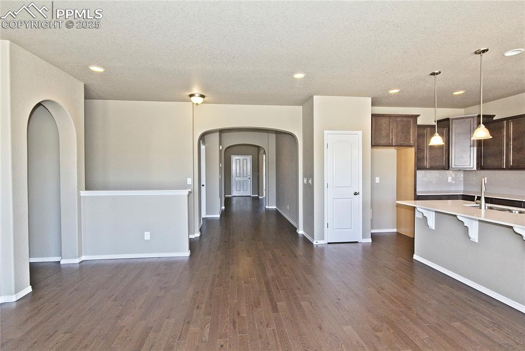Image 11 of 25: Kitchen featuring arched walkways, light countertops, recessed lighting, a