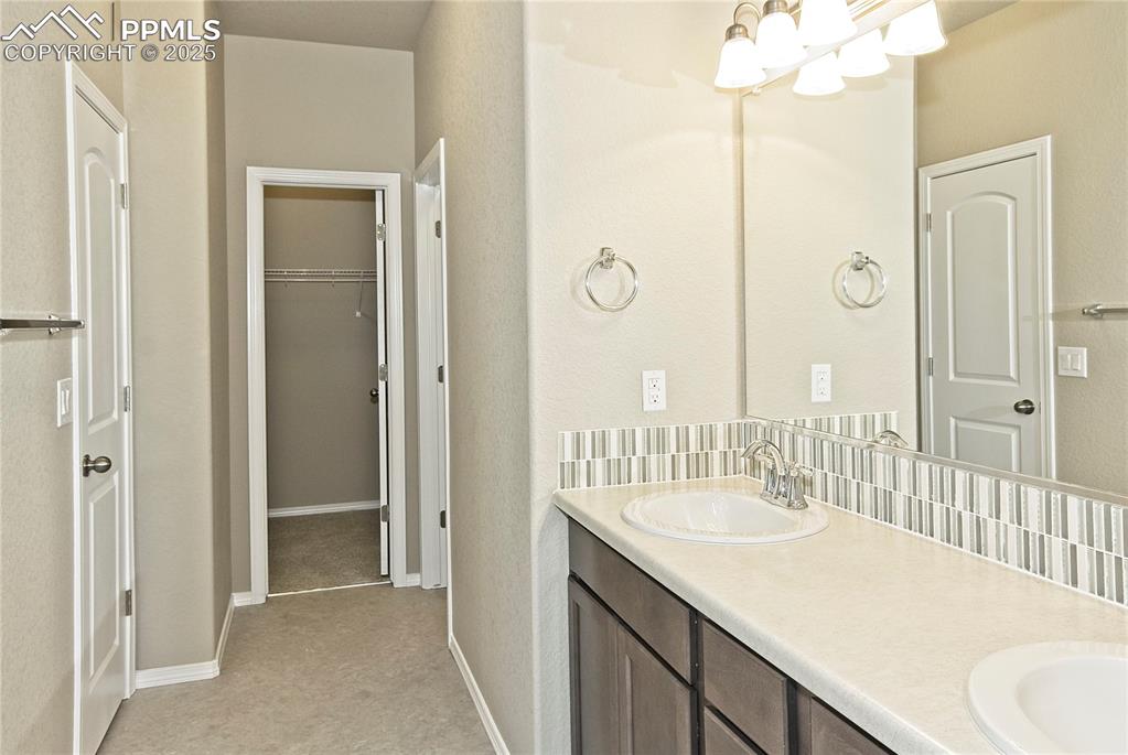 Image 15 of 25: Bathroom featuring double vanity and a spacious closet