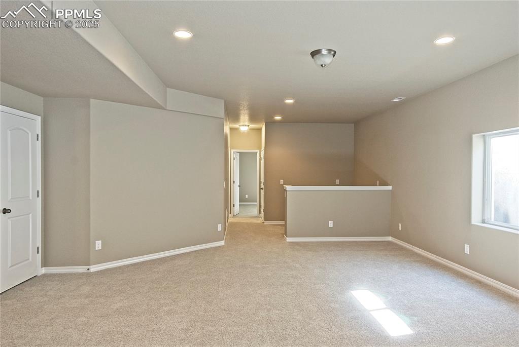 Image 20 of 25: Empty room featuring light colored carpet and recessed lighting