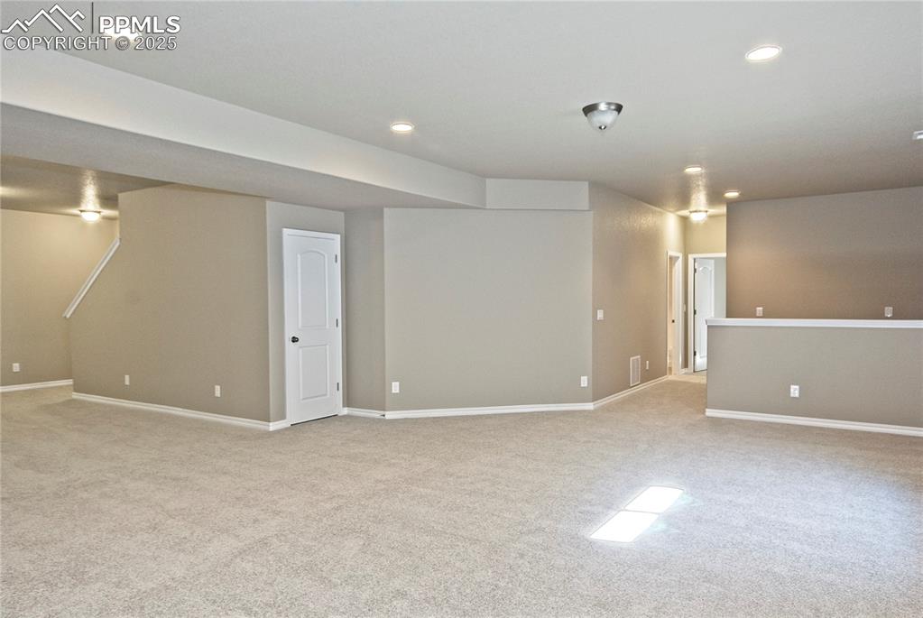 Image 21 of 25: Finished below grade area with light carpet and recessed lighting