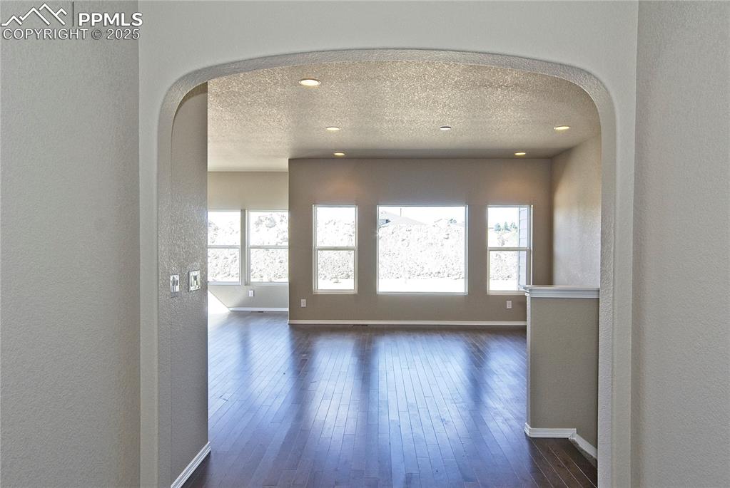 Image 3 of 25: Hallway featuring healthy amount of natural light, a textured ceiling, a te