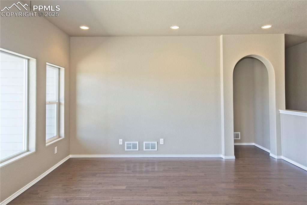 Image 6 of 25: Empty room featuring dark wood-style flooring and recessed lighting
