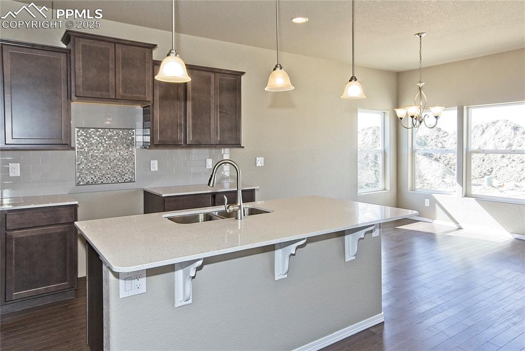 Image 7 of 25: Kitchen featuring backsplash, dark wood-style floors, a kitchen island with