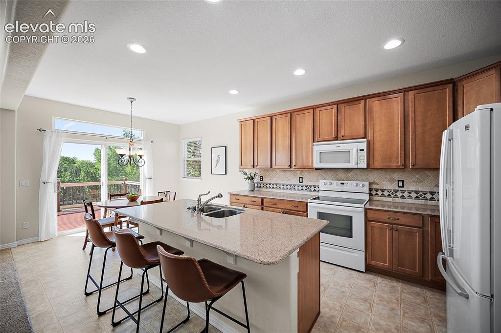 Image 12 of 40: Kitchen & Breakfast Bar, Nook & Sliding Glass Door to Deck