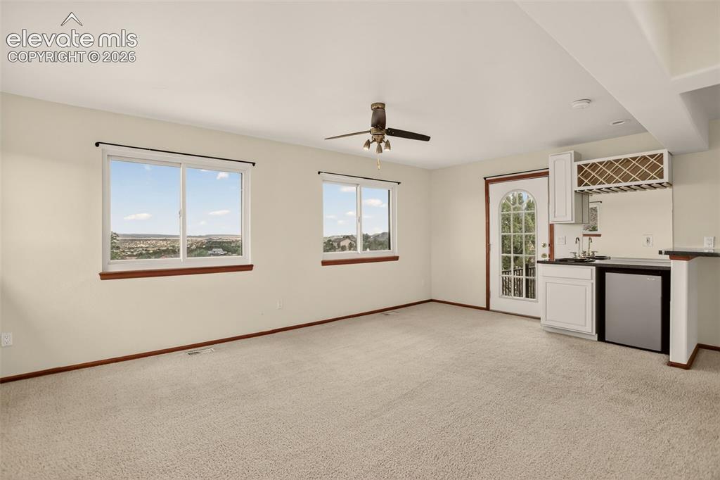 Image 30 of 50: Family room with wet bar and walkout to front patio. Entry to formal dining