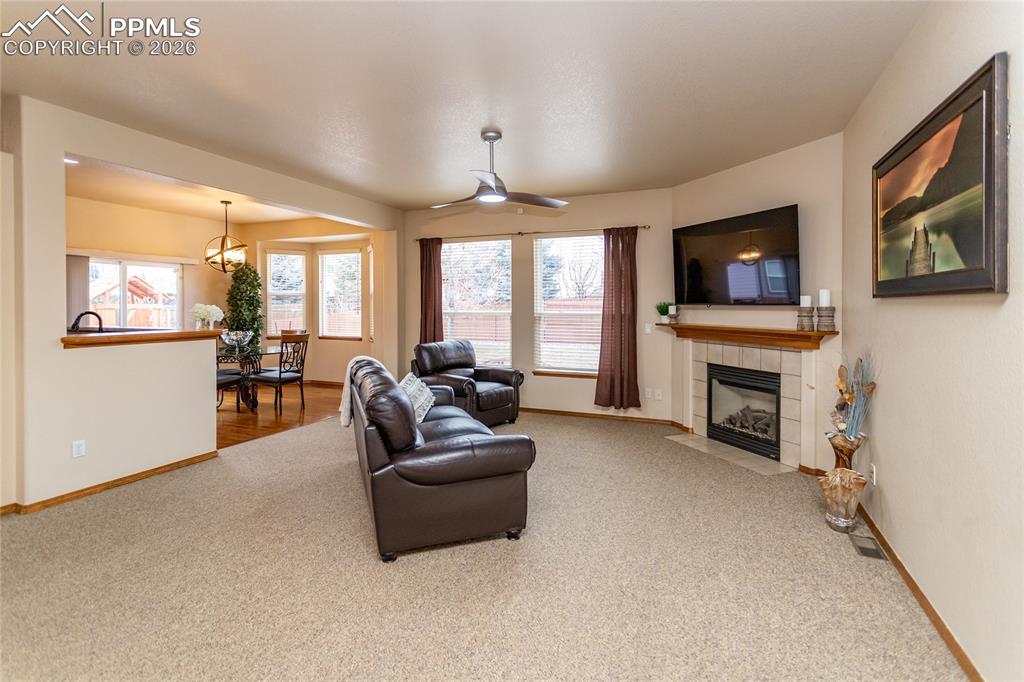 Image 11 of 50: Bright and specious great room has a gas fireplace with a tile surround.