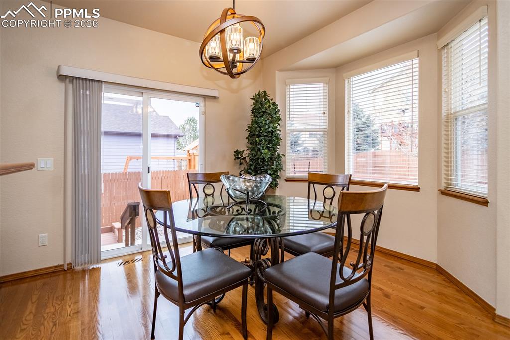 Image 14 of 50: Breakfast nook with hardwood flooring and a bay window walks out to the dec