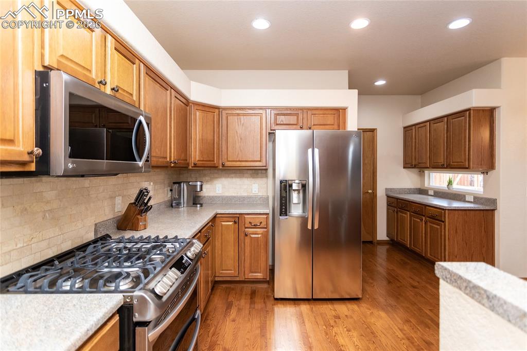 Image 17 of 50: Newer stainless steel appliances include a gas range with double ovens.