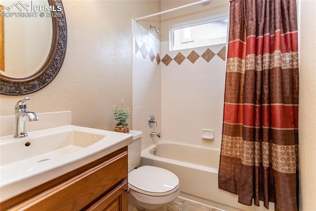 Image 31 of 50: Main level hall bathroom features a newer vanity and mirror and a tub/showe