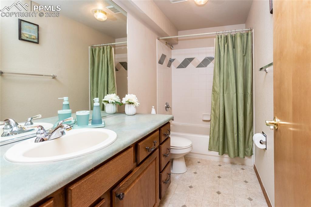 Image 39 of 50: Hall bathroom in the basement has an extended vanity and a tub/shower combo