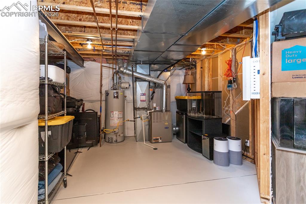 Image 42 of 50: Utility room in the basement offers plenty of storage space.