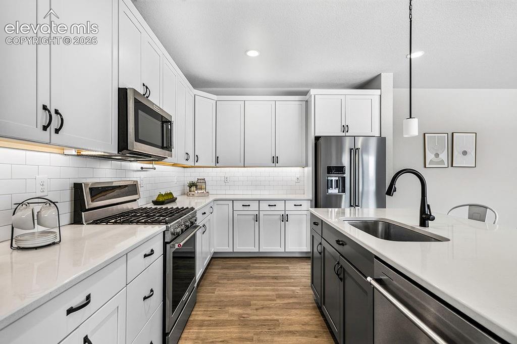 Image 16 of 47: Modern kitchen featuring white shaker cabinetry, stainless steel appliances